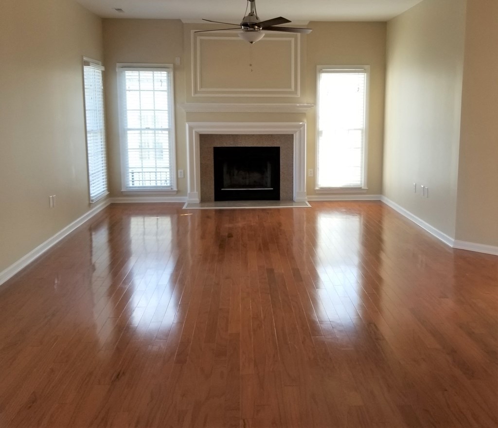 an empty living room with wooden floors and a fireplace