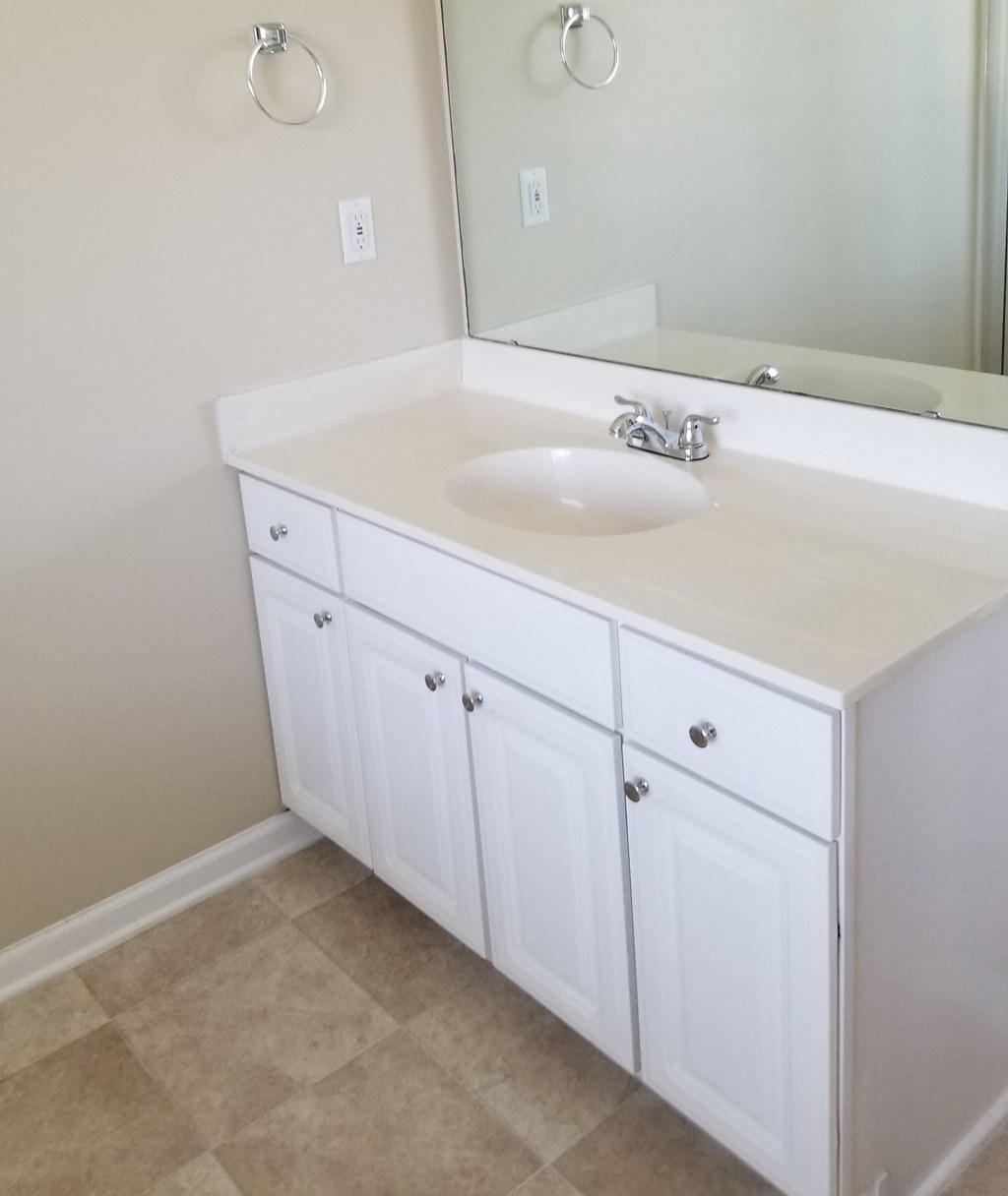 an empty bathroom with a sink and a mirror