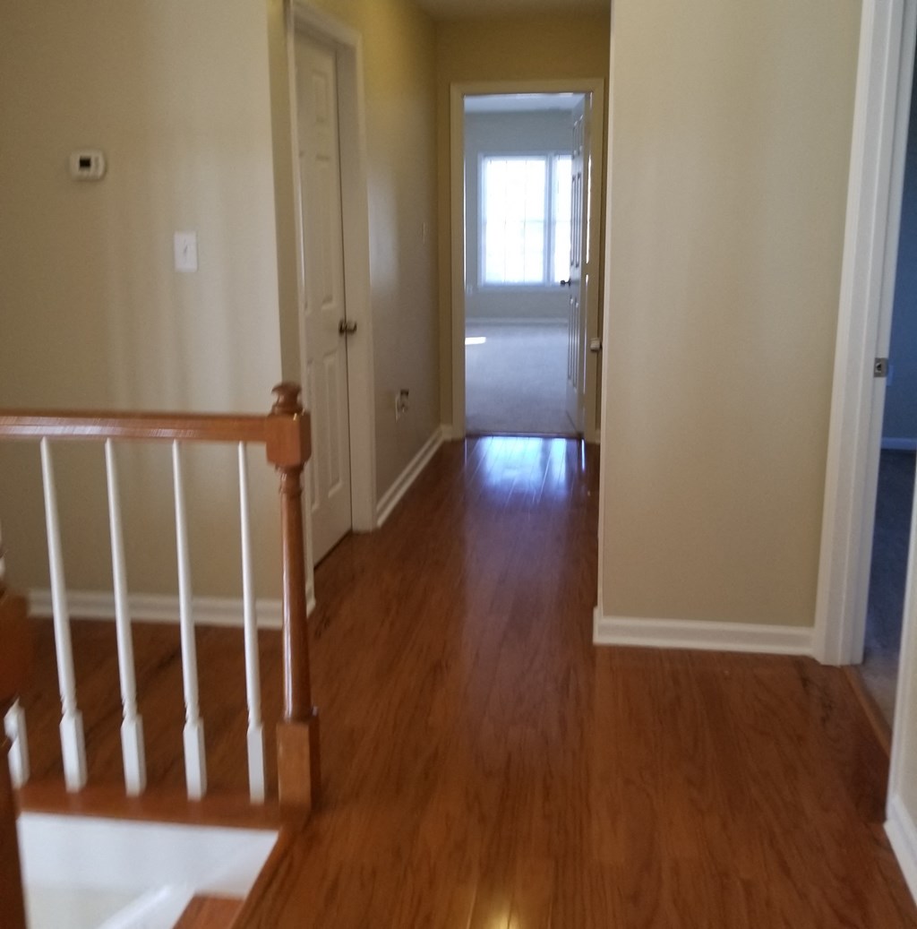 the view from the top of the stairs looking into the hallway of a house