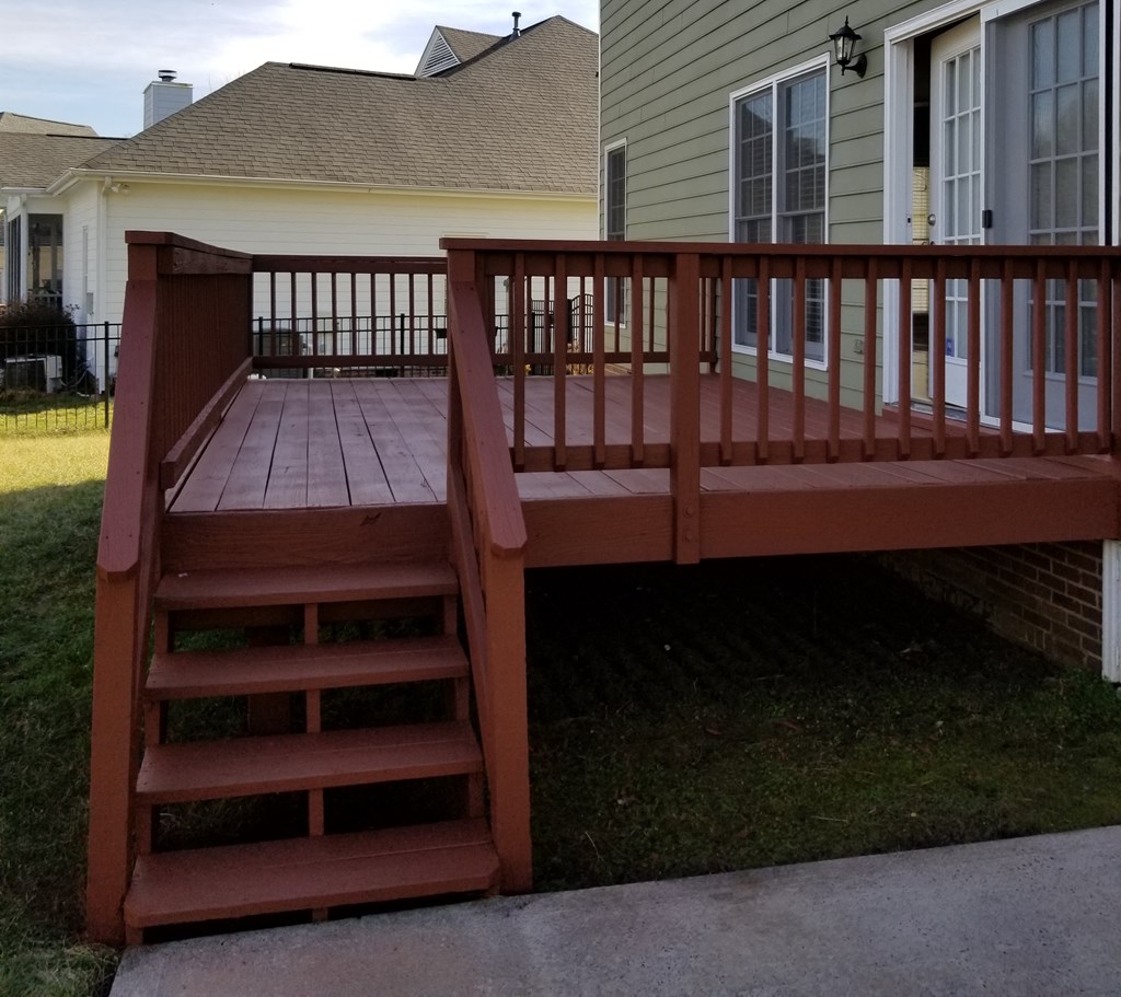 a deck with stairs in front of a house
