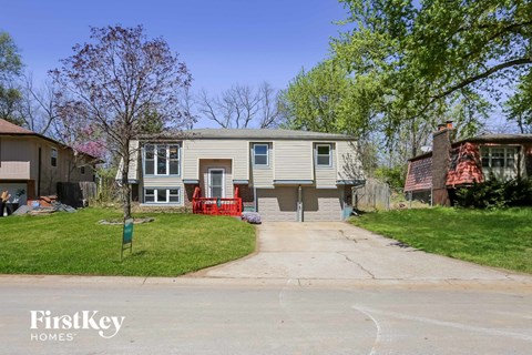 a white house with a red fence in front of it