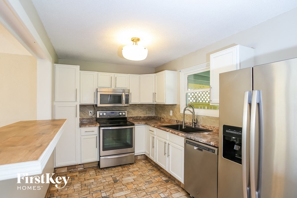 a kitchen with stainless steel appliances and white cabinets