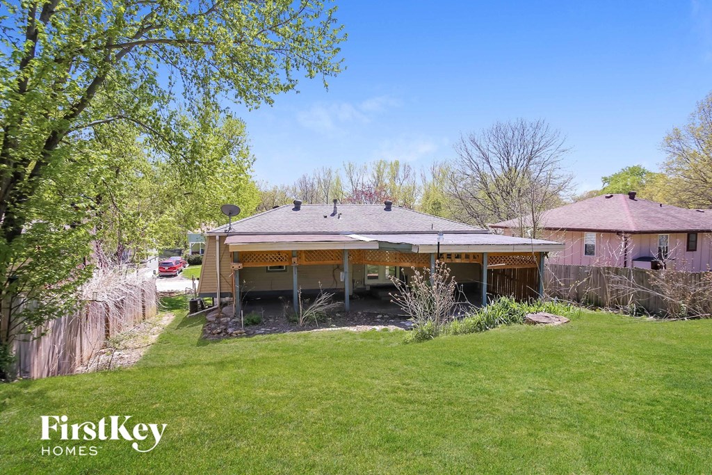 a backyard with a house and a green lawn