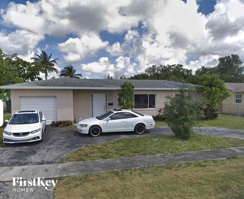 a house with two cars parked in front of it