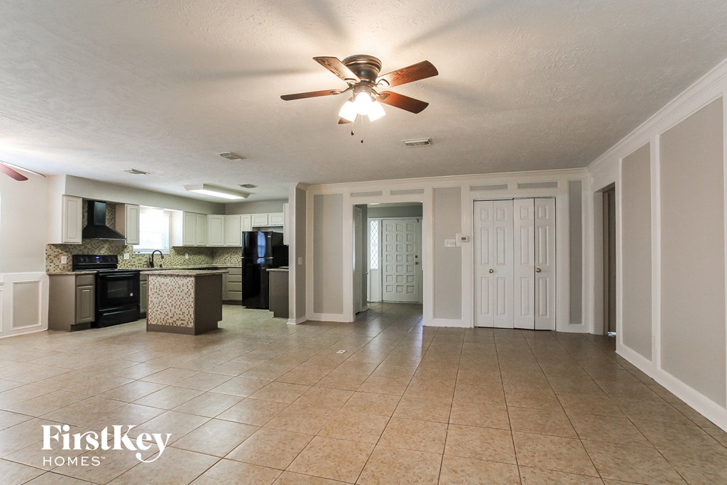 an empty kitchen and living room with a ceiling fan