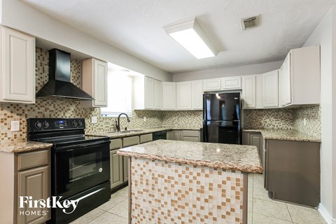 a kitchen with black appliances and a granite counter top