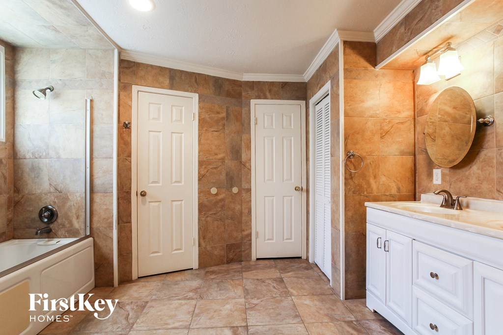 a bathroom with two doors and a sink and a shower