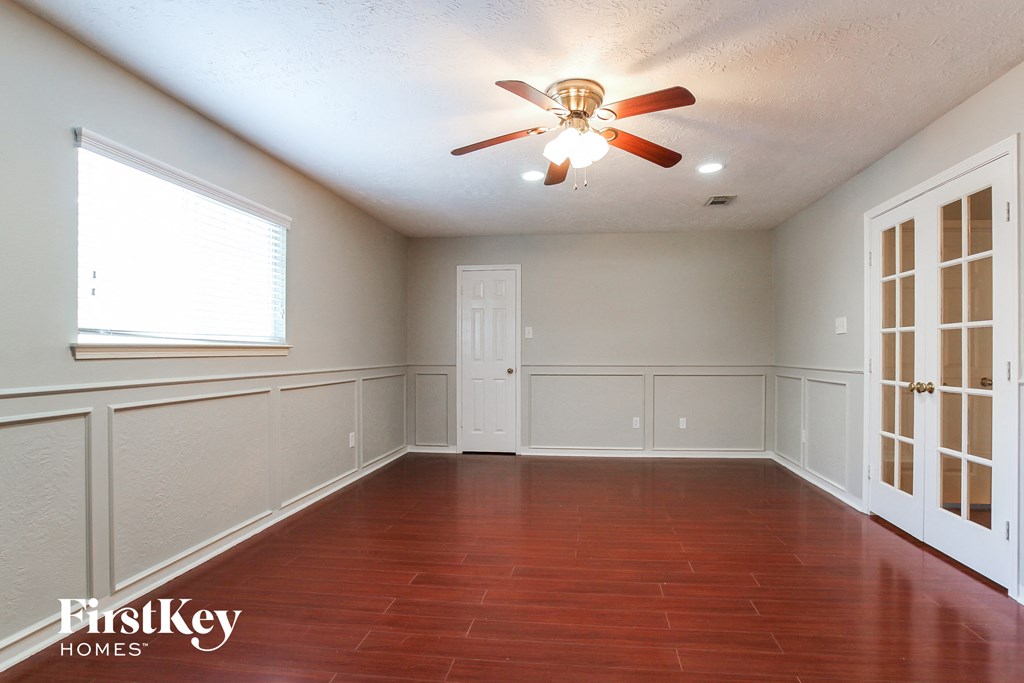 a empty dining room with a ceiling fan and a window