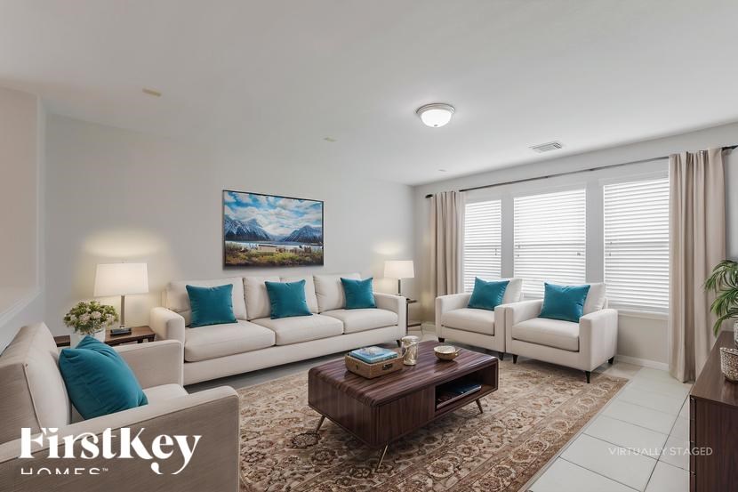 A virtual staged living room with a large painting, two couches, a coffee table, and a rug.