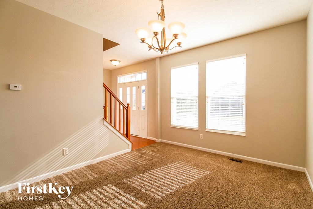 the entryway of a home with a carpeted floor and a staircase