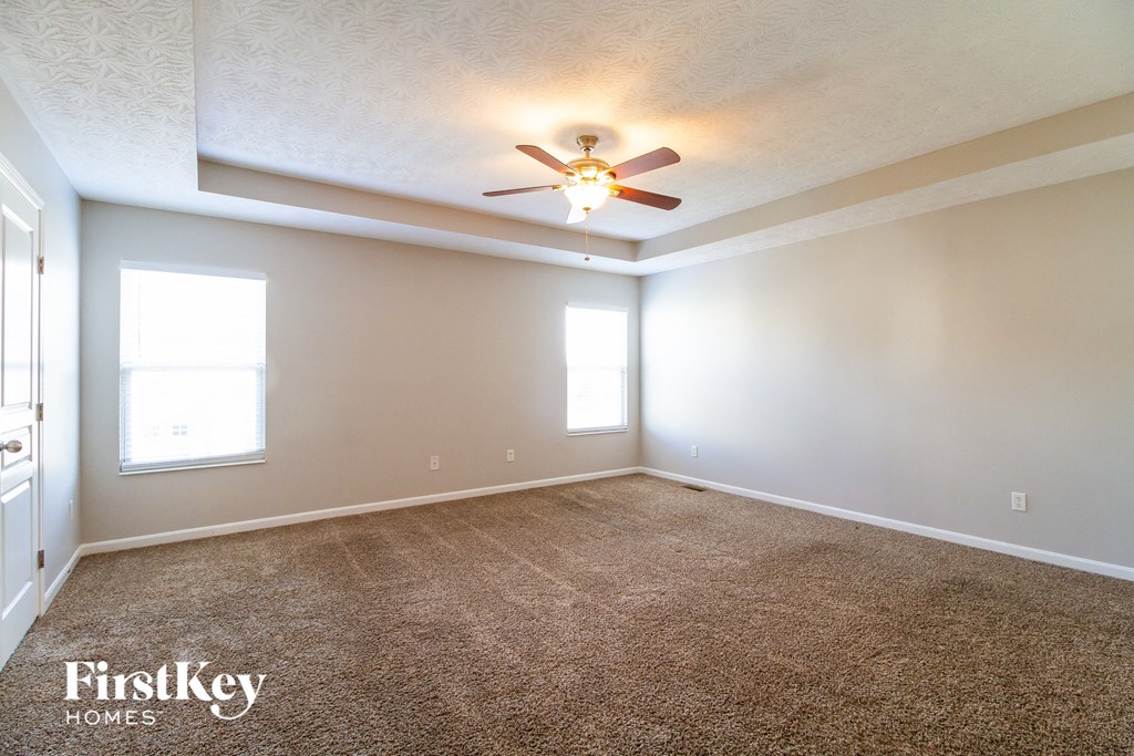 a living room with carpet and a ceiling fan
