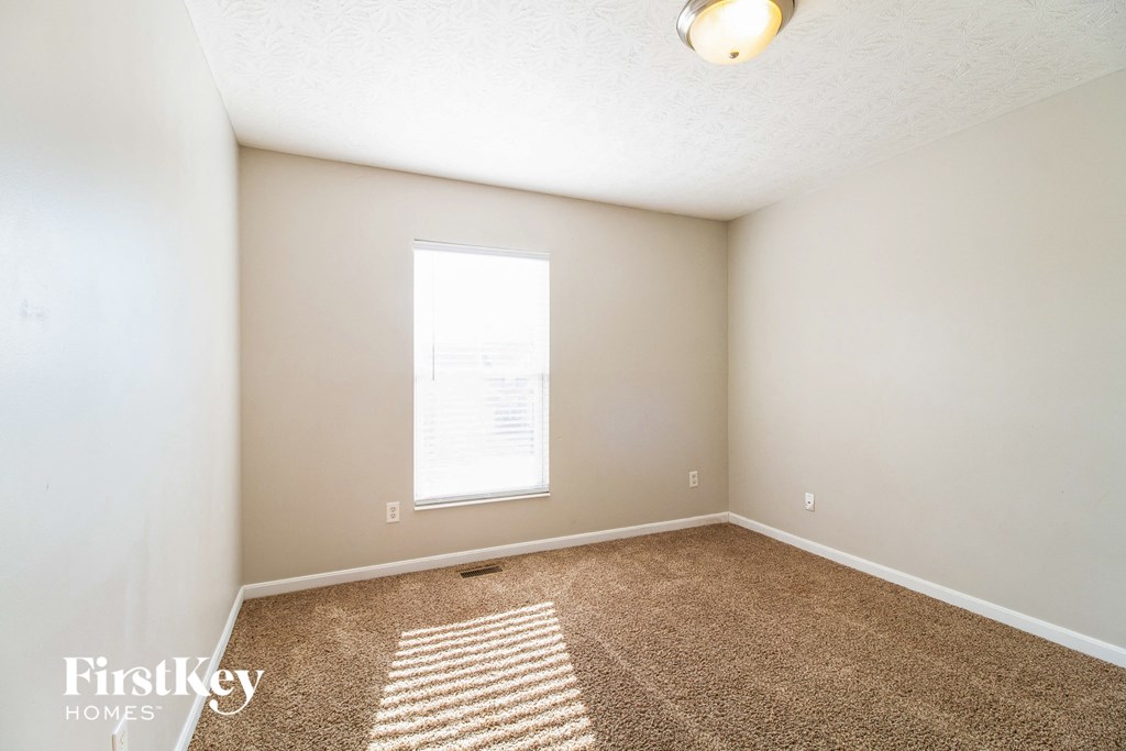 an empty room with carpet and a window