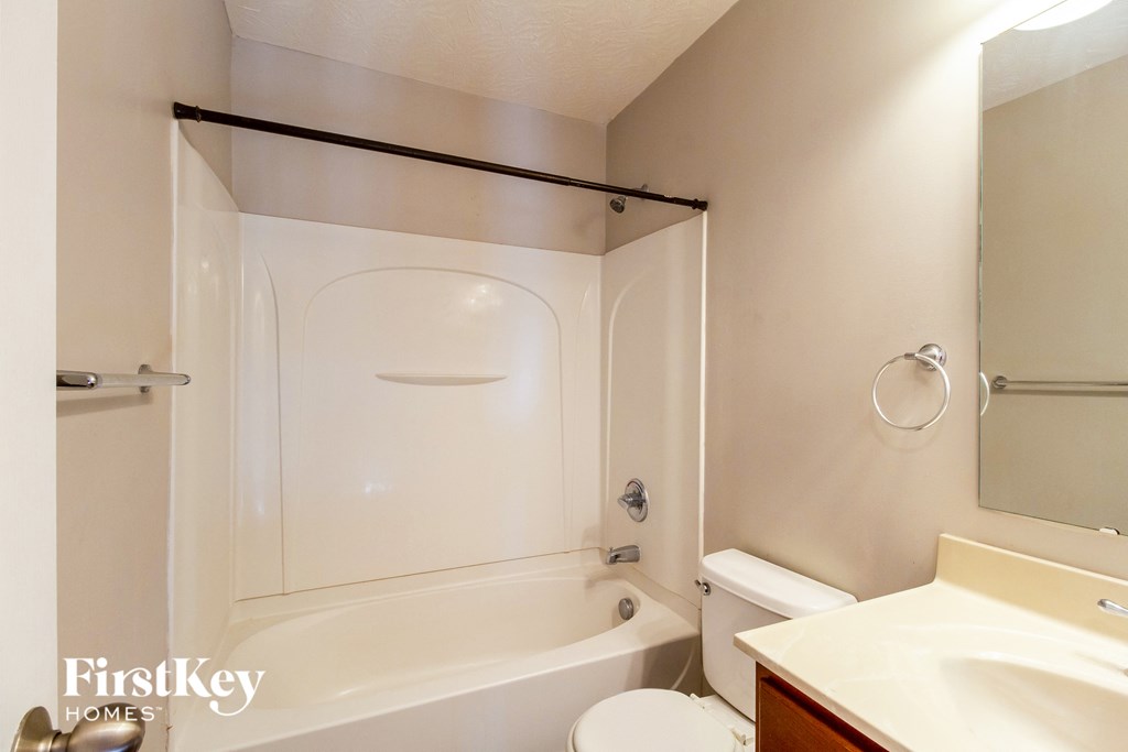 a bathroom with a shower and a toilet and a sink