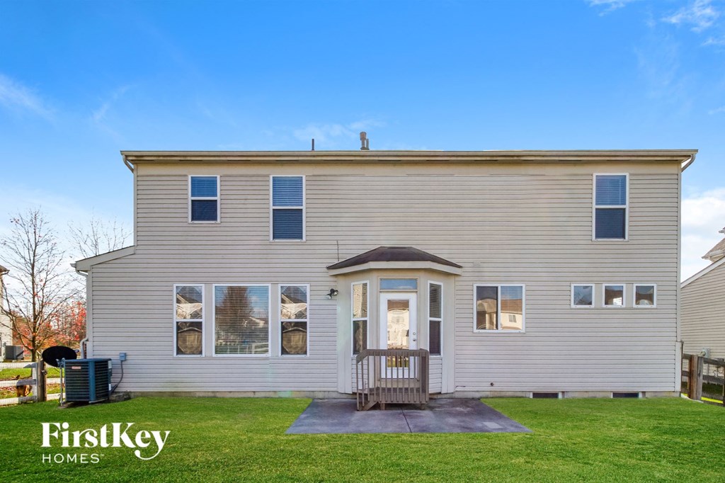 the front of a white house with a porch and a yard