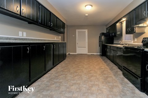 a kitchen with black cabinets and a sink and a refrigerator