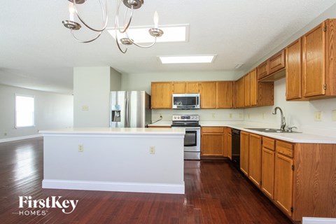 A kitchen with wooden cabinets and a white island.