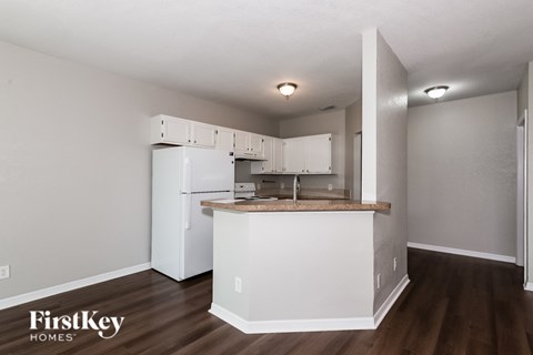 A kitchen with a white fridge and cabinets with a counter top.