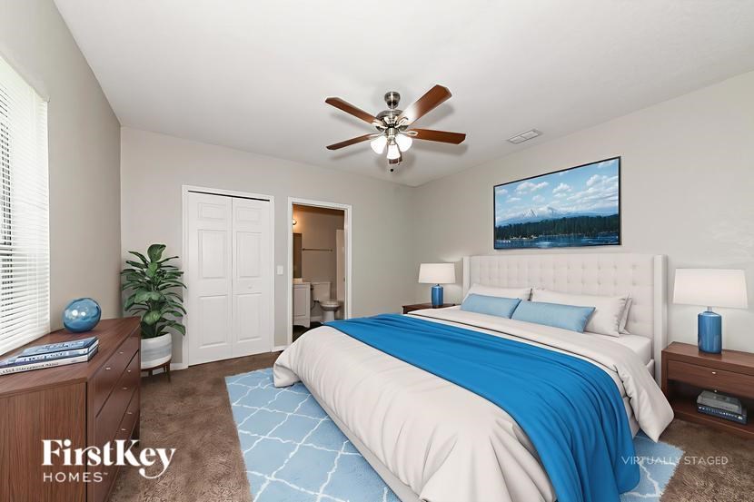 A bedroom with a large bed and a ceiling fan.