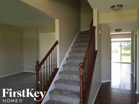 A staircase with a carpeted runner and wooden balusters.