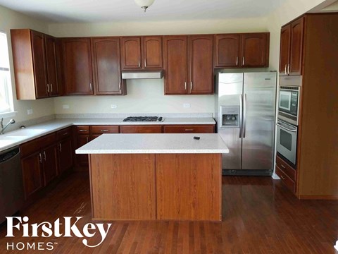 A kitchen with wooden cabinets and a white island.