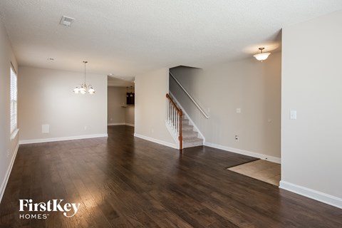the living room and dining room with hardwood flooring and stairs to the upper