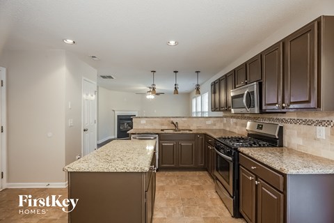 an updated kitchen with granite counter tops and stainless steel appliances