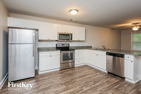 a kitchen with white cabinets and stainless steel appliances