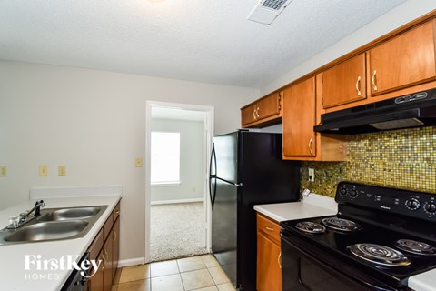 A kitchen with a black fridge and stove.