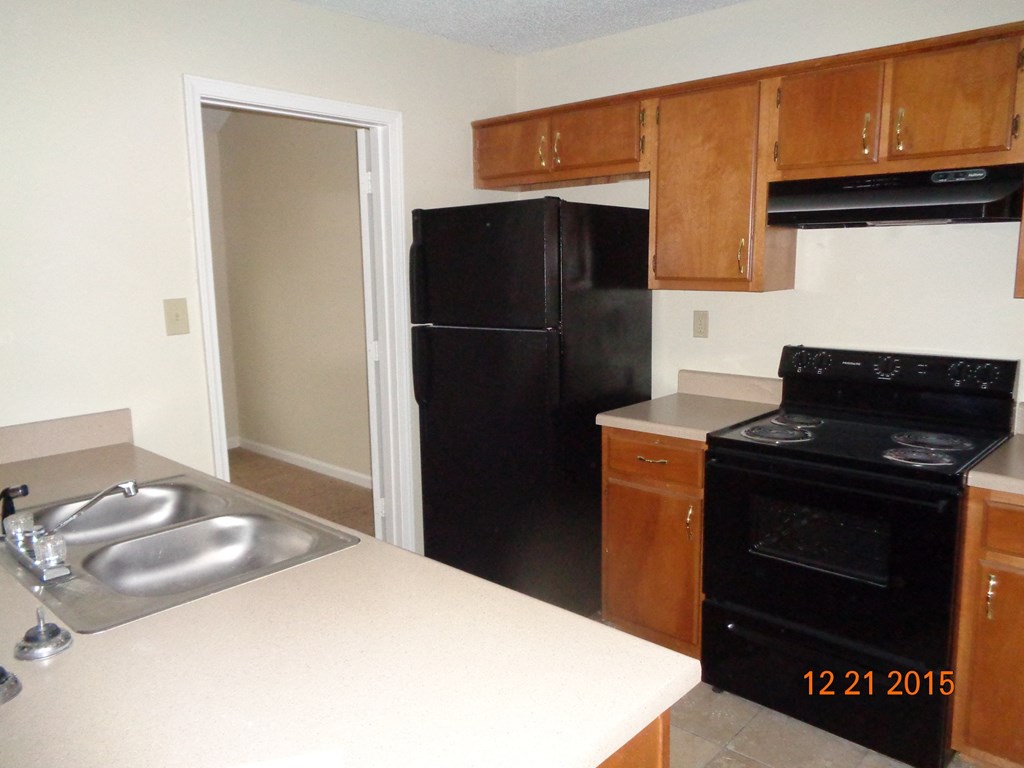 A kitchen with a black refrigerator and stove.