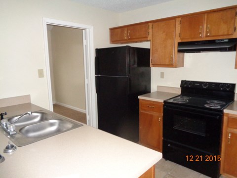 A kitchen with a black refrigerator and stove.