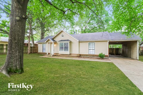 a white house with a yard and a tree