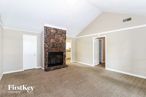 a living room with a fireplace and a carpeted floor