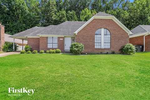 a brick house with a lawn in front of it
