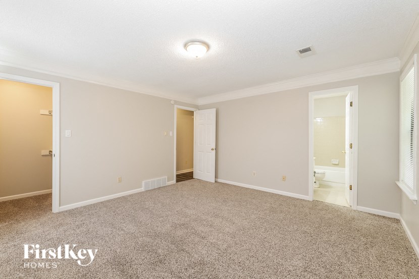 an empty living room with a door to the bathroom