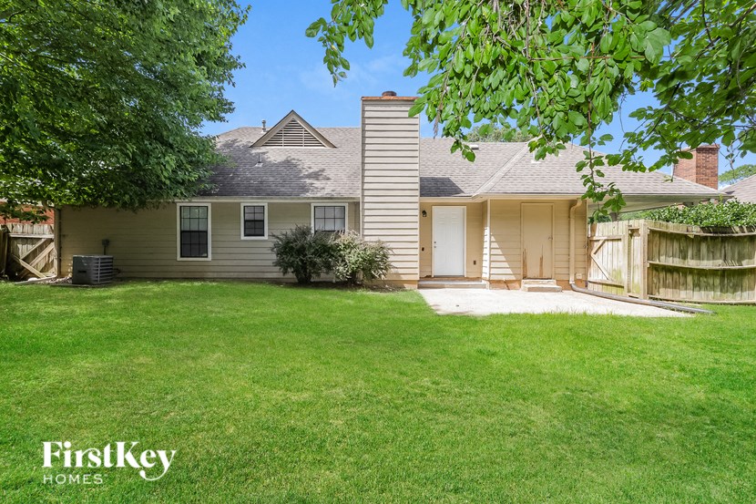 a white house with a yard and a backdoor