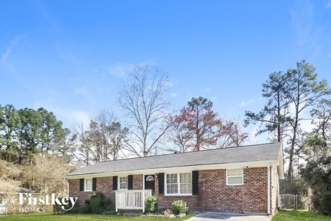 A brick house with a porch and a sign that says "Firstkey Homes".
