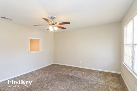A room with a ceiling fan and a window.