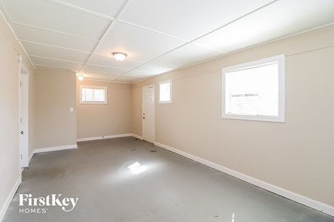 A spacious empty room with a window and a door.