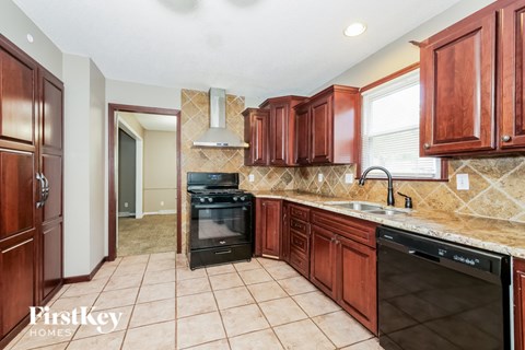 A kitchen with wooden cabinets and a tile floor.