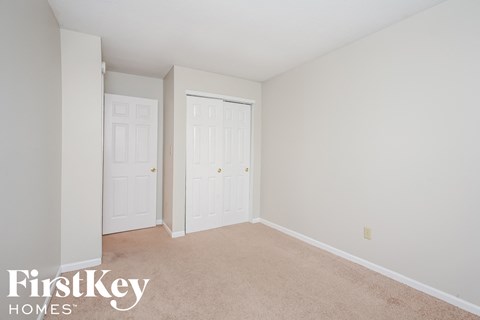 a bedroom with two closets and a carpeted floor
