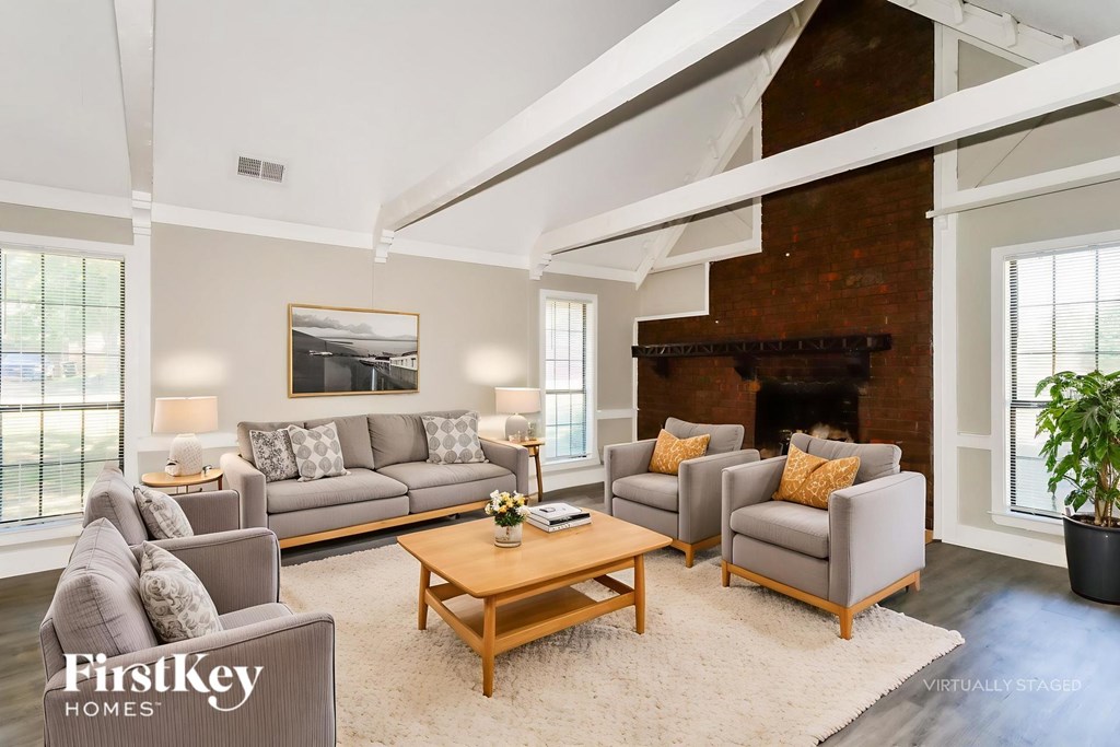 A living room with a fireplace and a painting on the wall.