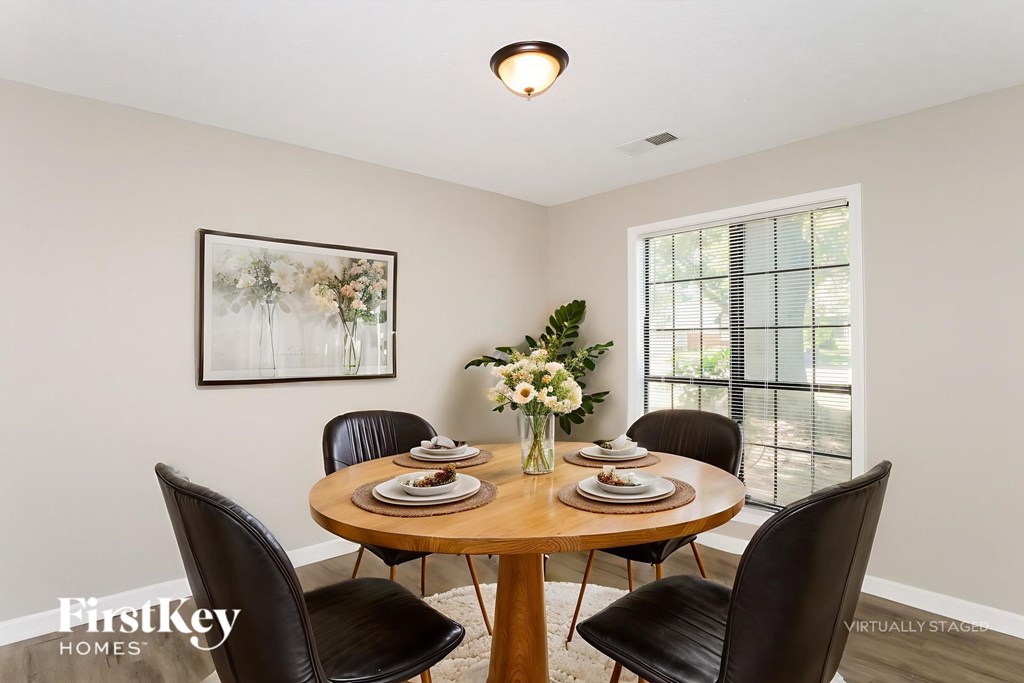 A dining room with a wooden table set for four.