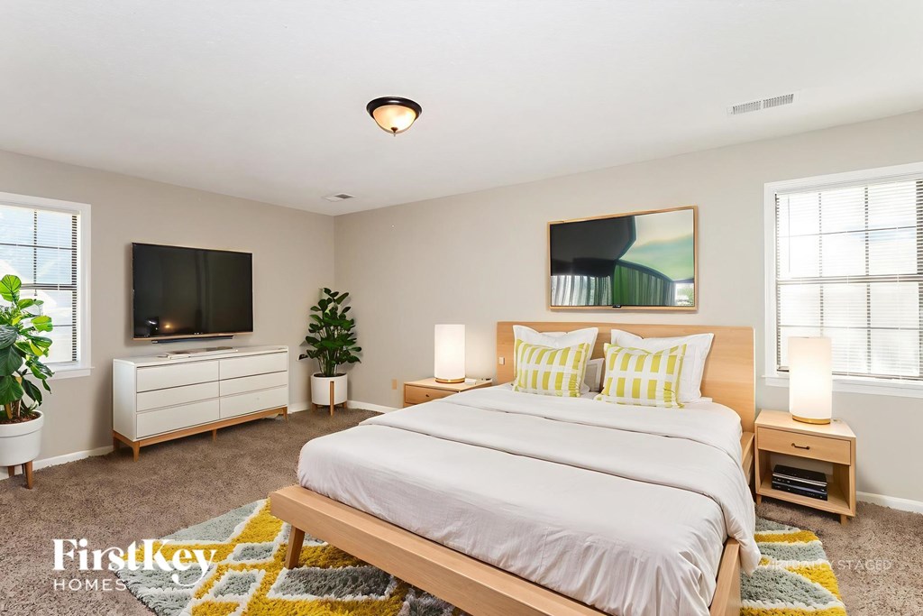 A bedroom with a large bed and a flat screen TV.