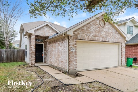 a tan brick house with a white garage door