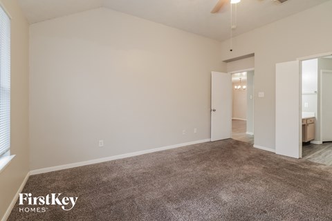 the living room of an apartment with carpet and white walls