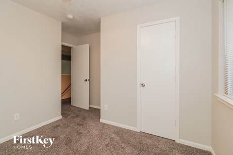 a bedroom with two closets and a carpeted floor