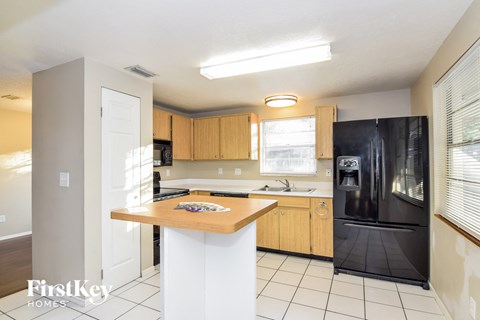 a kitchen with a island and a black refrigerator