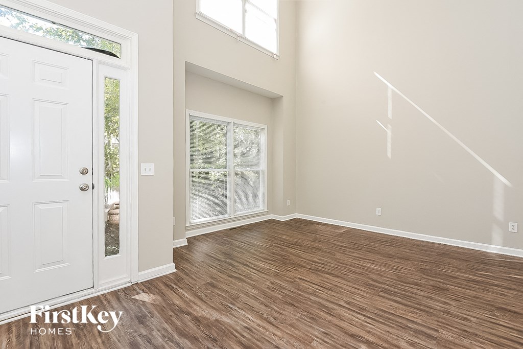 A room with wooden flooring and a white door.