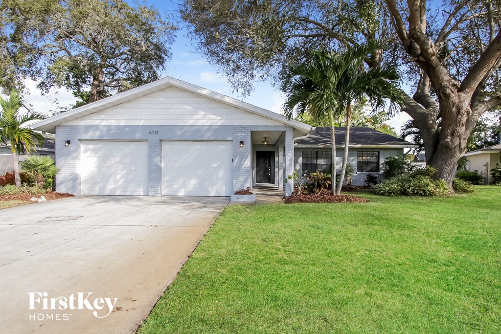 a white house with a driveway and a garage door