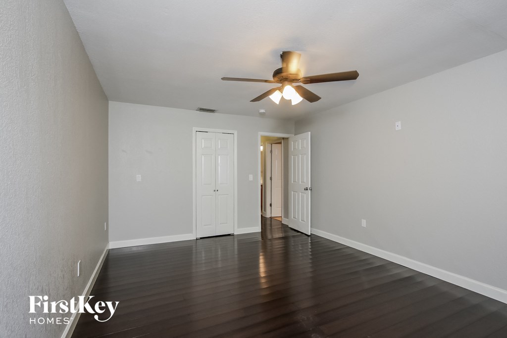 a living room with white walls and a ceiling fan